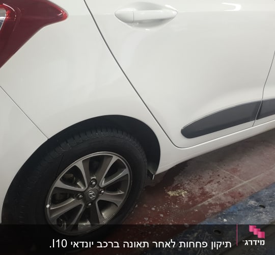 חלק אחורי של רכב לבן עם פגוש וצמיג